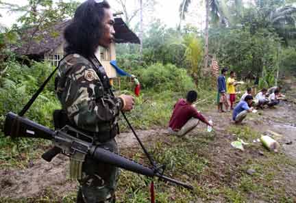 Hostages eat breakfast watched by a tribal gunman in San Martin, Prosperidas town in Agusan del sur province, (Photo: Reuters)