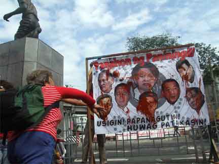 Human rights activists in the Philippines threw paint at images of President Arroyo and members of her party in protest of extra-judicial killings, 1 December 2009(Photo: Desaparecidos)