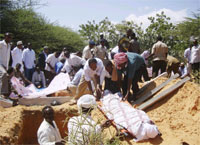 Burying one of the ministers killed in the attack, 4 December 2009(Photo: Feisal Omar/Reuters)
