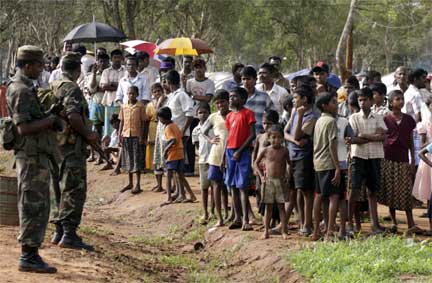 Soldiers and Tamils at a displaced persons camp, Vavuniya, 21 November 2009(Photo: Reuters)