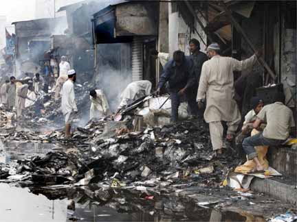 Shopkeepers survey destroyed shops, a day after they were set ablaze by an angry mob in reaction to the attack in Karachi(Photo: Reuters)