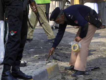 A policeman collects evidence at the site of the suicide bomb attack near a checkpost in Peshawar, located in Pakistan's North West Frontier Province.(Photo: Reuters)