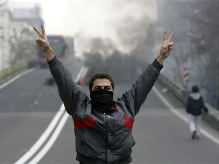 An Iranian protester, with his face covered, flashes victory signs during clashes in central Tehran on Sunday(Photo: Reuters)