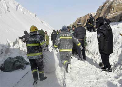 Policemen and firemen clear away snow that left a train stranded in Shangdu, Inner Mongolia.(Photo: Reuters)