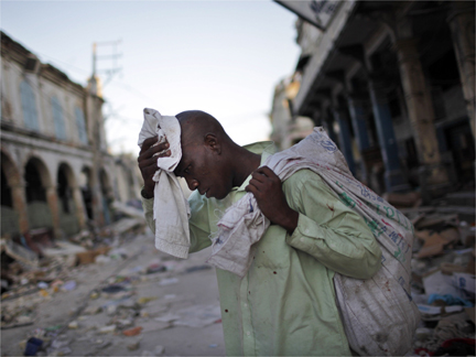 A man cleans himself as he walks through a destroyed street in Port-au-Prince(Photo: Reuters)