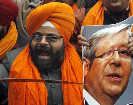 A Sikh activist brandishes a sword and a photo of Australian Prime Minister Kevin Rudd on a demonstration in Delhi(Photo: Reuters)