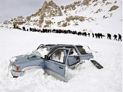 Rescuers head for the Salang tunnel as a car lies abandoned in the snow(Photo: Reuters)