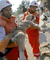 Los miembros de la Cruz Roja libanesa sacan el cuerpo de un niño de los restos de una casa, tras el masivo bombardeo israelí sobre la aldea de Cana.Foto: AFP
