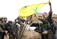 Soldados israelíes emprenden la retirada del sur del Líbano exhibiendo como trofeo una bandera del Hezbollah que se apropiaron en un combate.Foto: AFP