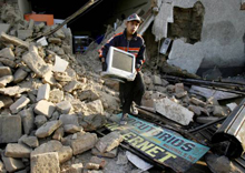 Perú: un joven de Ica recupera una computadora entre los escombros de casas destruidas por el sismo del 15 de agosto de 2007. Foto: Reuters