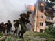 Soldados georgianos corren junto a un edificio en llamas tras un bombardeo ruso en Gori.Reuters