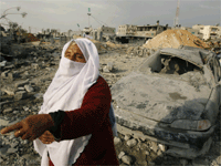 یک زن فلسطینی در میان خرابه های ناشی از بمباران هوایی اسرائیل غزه، با خبرنگاران صحبت می کند.(عکس: رویترز)