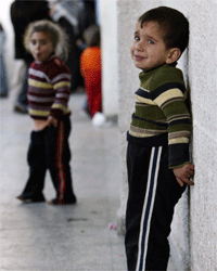 یک کودک فلسطینی اهل غزه. خانواده های فلسطینی به دلیل تخریب منازل خود در غزه در مدارس اسکان داده شده اند.(عکس: رویترز)