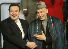 Gerhard Schröder et Hamid Karzaï à l'ouverture de la  troisième conférence internationale à Berlin sur la reconstruction de l'Afghanistan. 

		AFP