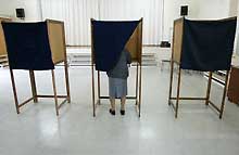 Une chypriote-grecque se prépare à voter. Malgré la victoire du oui dans la partie turque, seul le sud, partisan du <EM>statu quo</EM>, entrera dans l'UE le 1er mai. 

		(Photo: AFP)