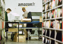 Des employés du site Amazon.fr travaillent dans l'entrepôt de stockage. 
 

		Photo AFP