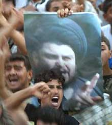 Des manifestants brandissent le portrait de Moqtada al-Sadr, le 28 mars 2004 à Bagdad. 

		(Photo: AFP)
