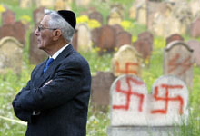 Un membre de la communauté juive se tient dans le cimetière juif d'Herrlisheim après la découverte de la profanation de 127 tombes. 

		(Photo : AFP)
