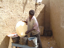 Moustapha Bakhar Yari, 14 ans, lave la vaisselle dans un restaurant de Bahaï. 

		(Photo : Stanislas Ndayishimiye/RFI)