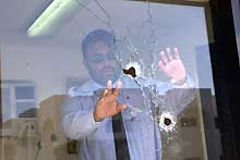 Un garde saoudien examine les vitres d'un hôtel à Yanbu, après une attaque terroriste contre des ingénieurs étrangers. 

		(Photo: AFP)