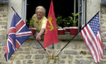 Une habitante de Colleville-sur-Mer dispose des drapeaux des pays alliés devant sa fenêtre. 

		(Photo : AFP)