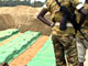 Le 17 août 2004, le personnel de l'ONU recouvre la fosse commune où sont inhumés les quelque 160 morts de Gatumba.(Photo : AFP)