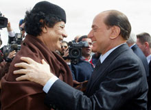 Le colonel Kadhafi et le Premier ministre italien Silvio Berlusconi lors de leur dernière entrevue en Libye en février 2004.
 

		(Photo : AFP)