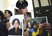 Ce <i>Carabiniere</i> tient les photos de Simona Torretta et de Simona Pari, kidnappées en Irak. 

		(Photo: AFP)