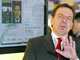 Le chancelier allemand Gerhard Schröder&nbsp;pose devant une reproduction de son passeport biométrique.(Photo : AFP)