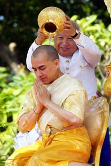 La cérémonie de couronnement de Norodom Sihamoni : le nouveau souverain reçoit la purification des mains de son père l'ex-roi Norodom Sihanouk. 

		(Photo : AFP)