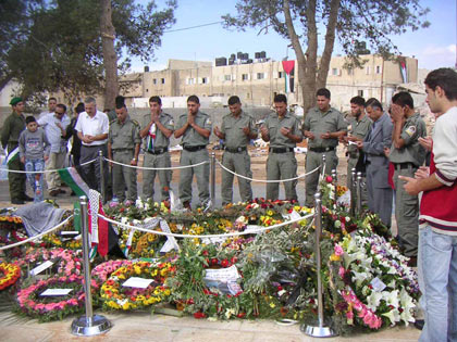 Au lendemain de la mort de Yasser Arafat, des membres de la garde présidentielle se recueillent sur sa tombe dans la cour de la Mouqataa. 

		(Photo: Manu Pochez/RFI)
