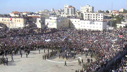 Alors que les funérailles de Yasser Arafat ont lieu au Caire, la population de Ramallah se masse autour de la Mouqata tandis que les forces de sécurité palestinienne tentent de dégager la place pour permettre l'aterrissage des hélicoptère. 

		(Photo: Manu Pochez/RFI)