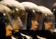 Des policiers, sous la neige, montent la garde devant le siège du gouvernement à Kiev. 

		(Photo : AFP)