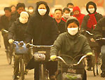 A Pékin, les cyclistes luttent contre les tempêtes de sable. 

		(Photo: AFP)