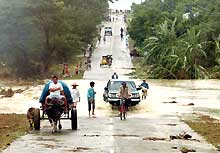 Dans les environs de Manille (province de Nueva Ecija), cette route a été submergée par les eaux du typhon <i>Nanmadol</i>. 

		(Photo: AFP)