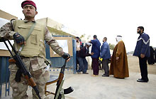 Un militaire irakien se tient devant un bureau de vote à Sadr City.(Photo: AFP)