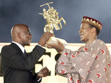Le réalisateur sud-africain Zola Maseko reçoit, pour son film <EM>Drum</EM>, l'Etalon de Yennenga des mains du président Compaoré à Ouagadougou le 5 mars 2005.(Photo : AFP)