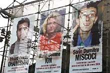 Les portraits des trois journalistes roumains enlevés en Irak, sont affichés, place de la Nation, à Paris, le 7 avril 2005.(Photo: AFP)