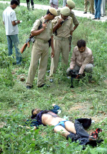 Des policiers indiens observent un journaliste filmant le corps d'un des six hommes armés qui ont attaqué mardi un site religieux sensible disputé entre hindous et musulmans à Ayodhya. Les assailliants ont été tués par les forces de sécurité qui, dans tout le pays, ont été placées en état d'alerte pour empêcher toutes violences religieuses.(Photo: AFP)