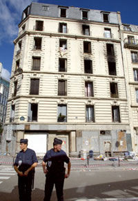 Des policiers se tiennent devant l'immeuble où s'est déclaré l'incendie dans la nuit du 26 août. Des travaux devaient être entrepris depuis longtemps.(Photo: AFP)