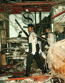 Des officiers de sécurité indonésiens constatent les dégâts causés par une bombe, dans le restaurant de Kuta sur l'île de Bali.(photo : AFP)