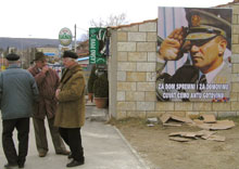 A Knin, des Croates se tiennent devant une affiche de soutien au général Ante Gotovina. (Photo: AFP)