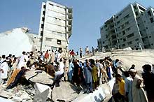 Les sauveteurs s'affairent sur un immeuble effondré d'Islamabad (Pakistan), après un violent tremblement de terre, le 8 octobre 2005.(Photo: AFP)