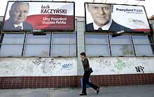 A Varsovie, un piéton passe sous les affiches électorales des deux principaux candidats à l'élection présidentielle polonaise de ce 9 octobre 2005.(Photo: AFP)