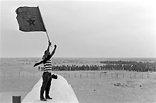 Un volontaire participant à la Marche verte tient le drapeau marocain, le 12 novembre 1975, à la frontière espagnole du Sahara occidental.(Photo: AFP)
