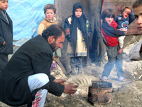 Najibullah allume un feu avant que la nuit tombe à l'entrée du conteneur qui abrite sa famille (6 enfants et 4 adultes) depuis quatre ans dans un camp de réfugiés le long d'une rue de Kaboul.(Photo : Anne Le Troquer/RFI)