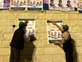 Des militants du Hamas collent des affiches. Pourtant, on parle de plus en plus d'un report des élections législatives.(Photo : AFP)