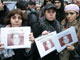 Des personnes présentent des portraits d'Ilan Halimi, le 19 février 2006 à Paris, lors d'une marche silencieuse en sa mémoire.(Photo : AFP)