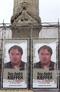 Posters géants de Guy-André Kieffer, affichés sur une des colonnes du Trône, place de la Nation, le 22 mars 2005 à Paris.(Photo : AFP)