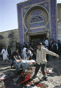 Des Irakiens évacuent les victimes de la mosquée de Bouratha à Bagdad le 7 avril 2006. Trois kamikazes déguisés en femme ont tué près de 80 personnes.(Photo : AFP)